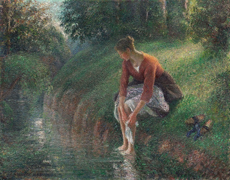 Женщина моет ноги в ручье