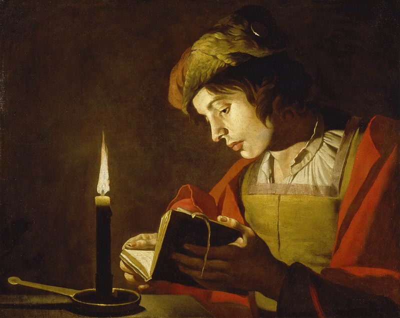 Молодой человек читает при свечах